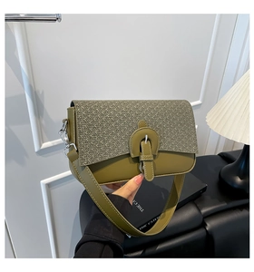 Detail of a two-tone crossbody bag with khaki woven texture and olive green leather material