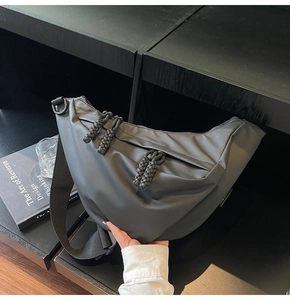 Detail der dunkelgrauen matten Tasche mit gewebten Reißverschlusszügen und Gurt