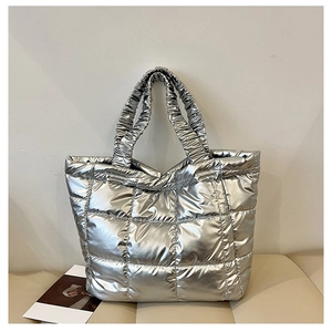 Detailed close-up of a silver quilted tote bag with metallic texture and ruched handles