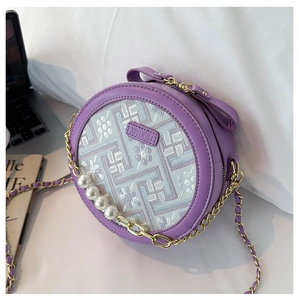 Detail of round purple crossbody bag with floral embroidery and pearl chain strap