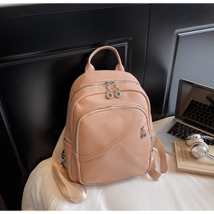 Detail of light pink lychee texture leather backpack with wide glossy gold shoulder straps