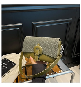 Detailed close-up of dark green crossbody bag with textured gray woven flap and silver buckles