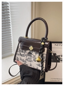 Detailed view of vintage crossbody bag with ink wash print and golden bell charm