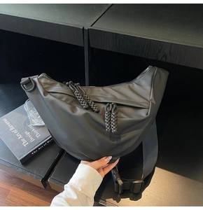Detail der schwarzen matten Nylon-Halbmondtasche mit gewebtem Reißverschluss und Gurt