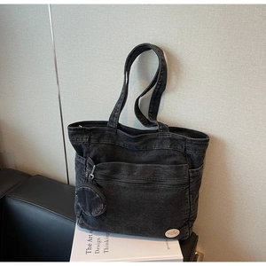 Detail of grey denim tote bag with functional pockets and a small round coin purse
