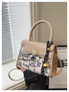 Close-up of landscape print canvas bag with golden clover lock and bell charm