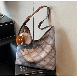 Quilted denim tote bag with brown leather straps and a matching round coin purse