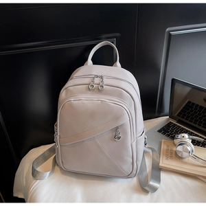 Detail of lychee pattern faux leather backpack with silver zippers and wide straps