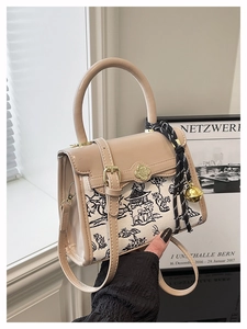 Close-up of contrast crossbody bag with ink painting canvas and retro metal buckle