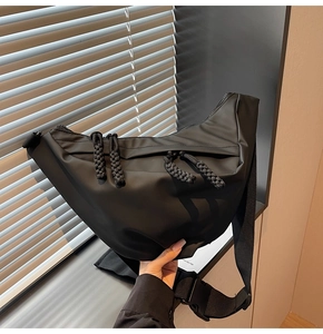 Detail der schwarzen Nylon-Umhängetasche mit gewebtem Reißverschluss und Schnalle