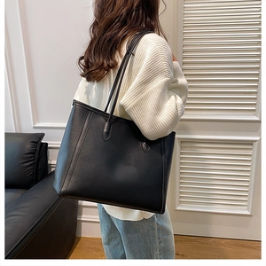 Detailed side view of the large black tote bag on model for casual commuting look