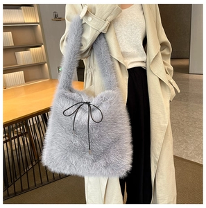 Détail de la texture en fausse fourrure grise et du nœud noir sur le sac cabas d'hiver