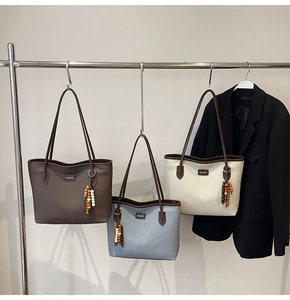 Detailed close-up of fashion tote bags in three colors featuring stylish wooden bead charms