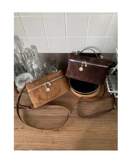 Detailed view of suede texture on mini crossbody bags with decorative metal zippers