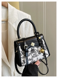 Detail of contrast handbag featuring ink wash painting pattern and floral buckle
