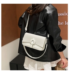 Close-up of white leather handbag detail showing silver metal buckle and matte texture