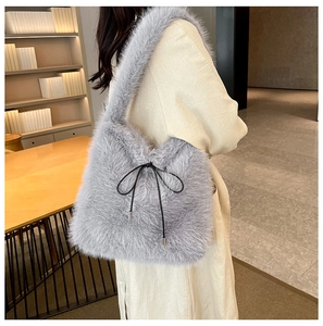 Détail du sac à épaule en fausse fourrure grise avec nœud décoratif en cordon noir