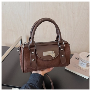 Détail du sac seau léopard en daim avec rivets argentés et pendentif en cœur