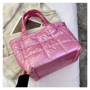 Detailed view of pink quilted tote bag with metallic finish and ruffled puffer handles