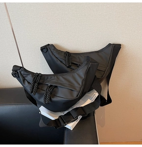 Detail der schwarzen Halbmond-Umhängetasche mit geknoteten Reißverschlüssen und Nylon-Struktur