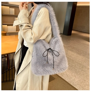 Détail d'un sac à épaule en fausse fourrure gris clair orné d'un petit nœud noir élégant
