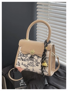 Detail of vintage crossbody bag showing beige leather, landscape canvas, and gold lock