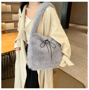 Mannequin portant un sac cabas en peluche grise avec nœud noir et trench beige