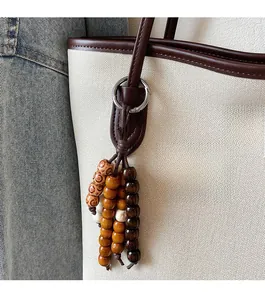 Detail of bohemian wooden bead bag charm with vintage patterns on a canvas tote