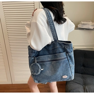 Detail view of retro washed blue denim tote bag with side pockets and mini coin purse