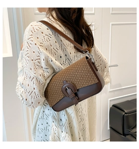 Detail of bohemian quilted crossbody bag with textured woven flap and brown leather strap