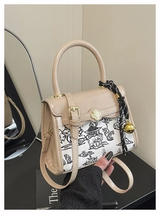 Detail of the elegant beige crossbody bag featuring ink landscape print and floral lock