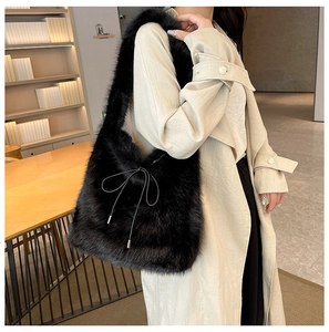 Détail d'un sac à épaule en fausse fourrure noire avec décoration de ruban à nœud