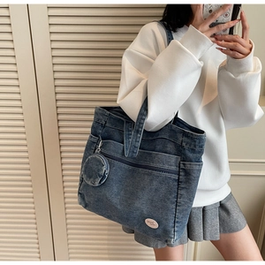 Detail of blue denim tote bag with side pocket and round mini coin purse attachment