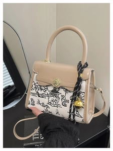 Detail of beige contrast handbag with landscape print and clover twist lock