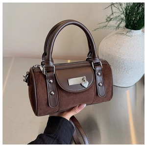 Vue détaillée du sac baril vintage marron montrant les textures et le pendentif en cœur