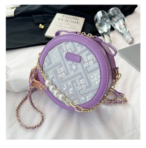 Detail of purple round crossbody bag with floral embroidery and pearl chain accents