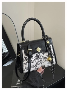 Detail view of contrast color crossbody bag with Chinese landscape print and flower clasp