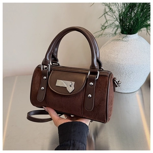 Détail du sac cylindre marron foncé avec patchwork de daim et pendentif en cœur