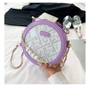 Detail of lavender round bag with pearl chain strap and floral embroidery texture