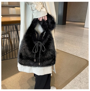 Détail d'un sac à main en fausse fourrure noire avec nœud coulissant en cuir fin