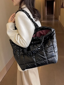 Black quilted down tote bag with pleated handles and large capacity on female model