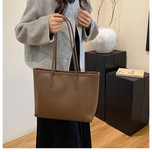 Artistic detail of a brown minimalist tote bag with thin straps for daily commuting