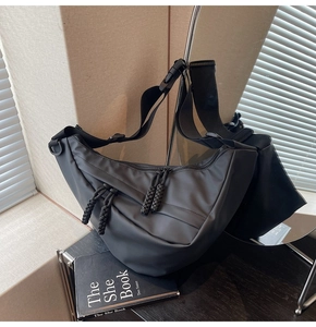 Detail eines verstellbaren Nylon-Schultergurts mit robuster Schnalle an einer schwarzen Tasche