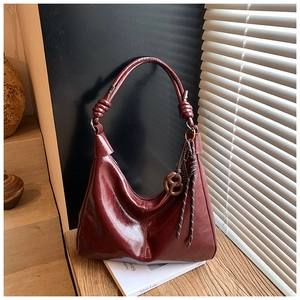 Detail of burgundy oil wax leather hobo bag with a woven knot shoulder strap