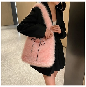 Détail du sac cabas en fausse fourrure rose avec nœud noir sur peluche douce