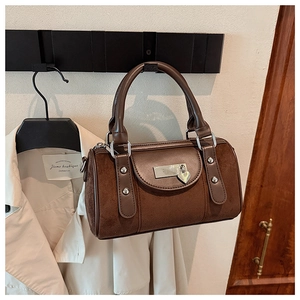 Gros plan du daim marron foncé avec rivets métalliques et breloque en forme de cœur