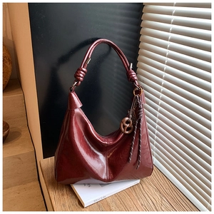 Deep red-brown hobo shoulder bag with knotted handle and walnut pretzel charm detail