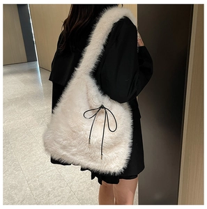 Gros plan détaillé d'un grand sac cabas en peluche blanc crème avec un nœud noir