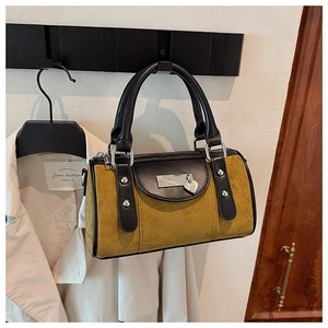 Détail du sac seau en daim gingembre vintage avec poignées en cuir et pendentif coeur