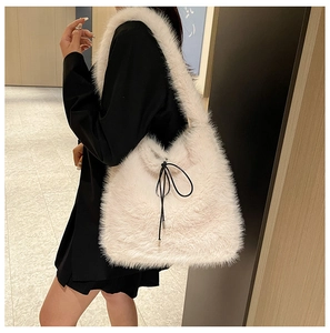 Gros plan du sac bandoulière en fausse fourrure blanc crème avec détail de cordon noir